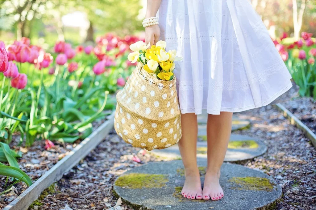 beautiful spring background of a girl carrying a basket of pretty flowers