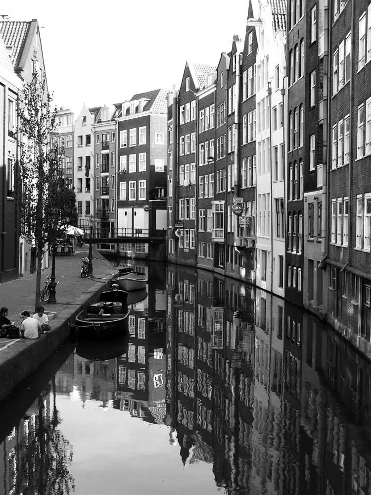 a photo of a river next to buildings